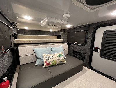 A picture of the Encore RV 12BH Interior with bed and throw pillows