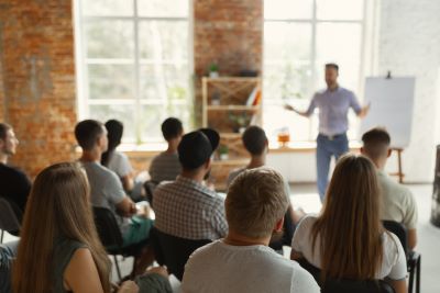 A picture of an instructor in front of a classroom of students