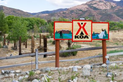 A picture of KOA Campground sign with a mountain in the background