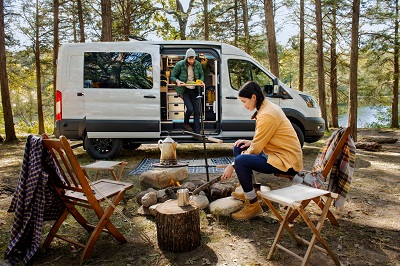 A picture of the 2023 Ford Transit Trail with a Campfire and Family