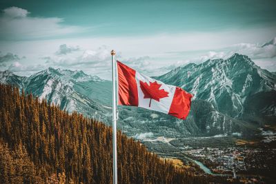 A picture of the Canadian flag against the Rockies