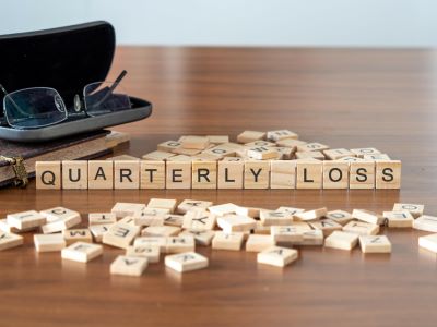 A picture of Scrabble tiles spelling out the words Quarterly Loss on a desk