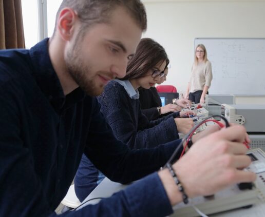 A picture of a young man in a blue shirt testing a part during a technical training class