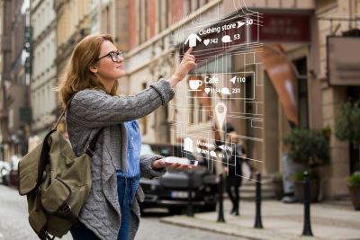 A picture of a young woman with a backpack touching an ordering screen in the air depicting augmented reality