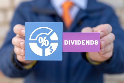 A picture of a person holding a percentage graph and a placard reading "dividends" to symbolize quarterly cash dividends