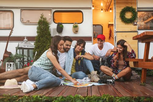 A picture of a group of young adults planning RV travel outside with a map