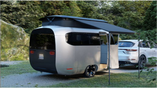 A picture of the exterior of the Airstream Porche collaboration concept travel trailer with its pop top open and awning extended.