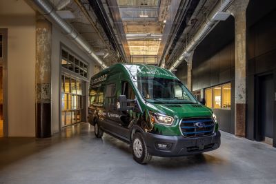 A picture of the exterior of a G1 model Grounded, green, Type B all-electric motorhome inside a showroom