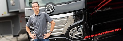 A picture of Helio Castroneves in front of his American Eagle Coach in 2023