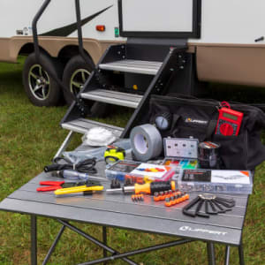 A picture of the Lippert RV Toolkit spread out on a table in front of an RV doorway
