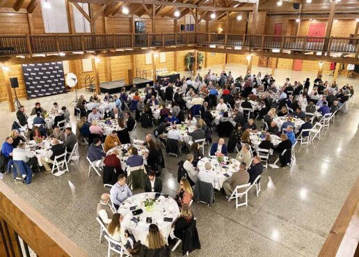 A picture of many people sitting at white-topped tables during the 2023 Newmar Supplier's banquet