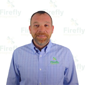 A picture of Enos Miller, Firefly Integrations VP of Tech Support; he is wearing a blue shirt and standing against a completely white background.