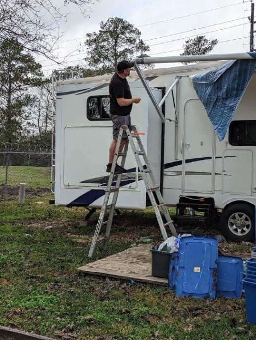 A picture of Jamie Sieger, RV mobile Tech, working on an RV awning