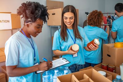 A picture of two female young adults cataloguing and packing food items at a food bank