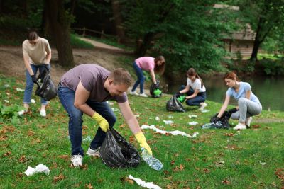 A picture of a group of young men and women cleaning up trash in a park