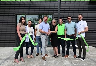 A picture of the Genesis team cutting the ribbon outside of Plant 10 in Indiana