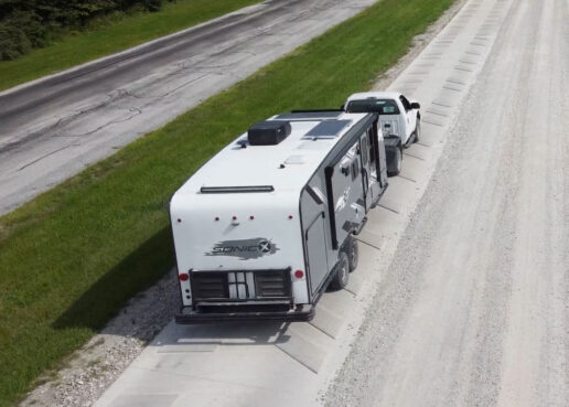 A picture of the Venture RV sonic X travel trailer being pulled behind a truck on the highway