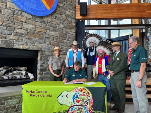 National Park Service and Parks Canada representatives sign a memorandum of understanding.