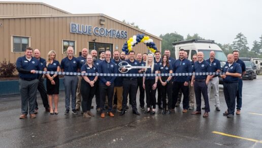 A picture of Blue Compass RV executives and employees at a ribbon-cutting outside a store finishing its brand rollout.