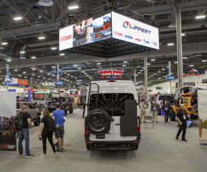 A picture of Lippert's 2021 booth at the SEMA show, with a custom-built vehicle on display.