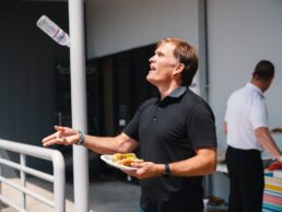 A picture of Airstream Adventures Northwest founder Ted Davis flipping a water bottle in the air at a company BBQ event.