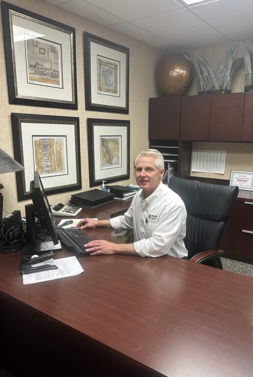 A picture of Paul Cunningham, general manager of Campers Inn of Louisville, sitting at the desk in his office.