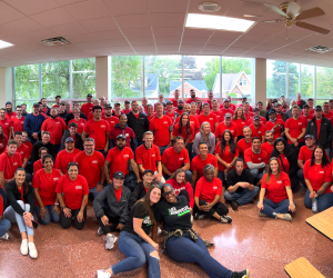 A picture of Lippert employees, wearing red shirts, gathered for a team picture after volunteering to help a Michigan nonprofit rehab a facility in Sterling Heights.