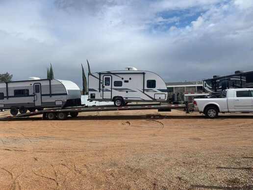 A picture of a Nationwide United Auto Transport RV transport driver in a truck pulling a pair of RVs.