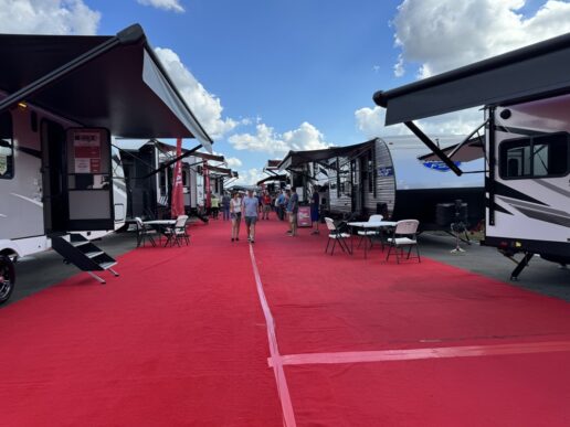 A picture of the corridor at the 2023 Tampa Bay fall trade show, with a red carpet lined by RVs on either side.