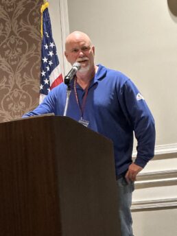 A picture of Keller Marine & RV President Mike Keller addressing 2023 show attendees from the podium.