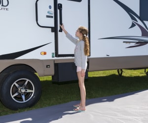 A picture of a child using Lippert's LatchXtend RV door handle extension.