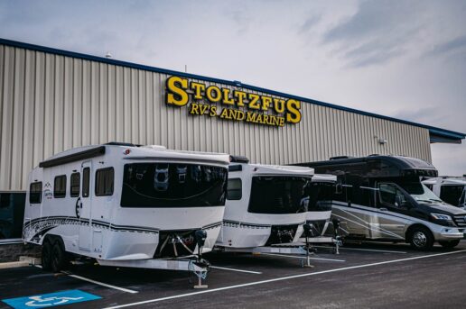 A picture of the Stoltzfus RV's and Marine sign on the showroom exterior with RVs lined up in front of the building.