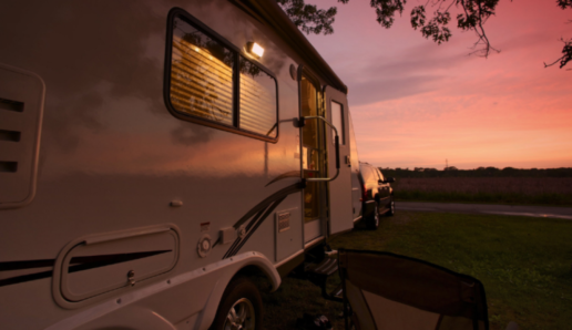 A picture of the side of an RV as the sun sets.
