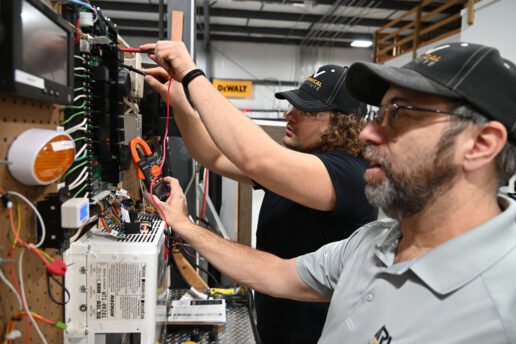 A picture of Level 2 trainee Dyllan Eyestone (at left) checking voltage levels with instructor Chris Jachim watching the voltage meter during electrical lab training at the RV Technical Institute.