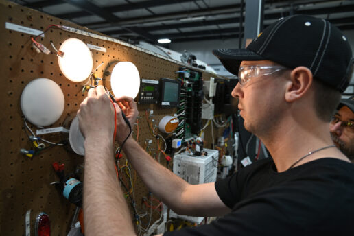 A picture of Level 2 trainee Andrew Kane testing voltage levels on lights during electrical lab training at the RV Technical Institute.