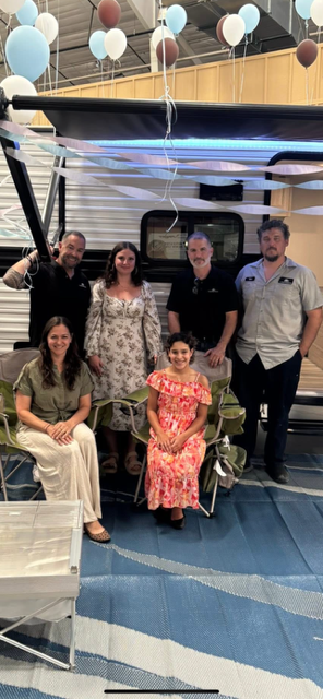 Staffers at Lazydays RV of Loveland pose with Make-A-Wish recipient Adhalia and her mom in front of the Heartland RV travel trailer they received.