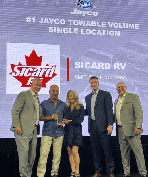 A photo of Sicard RV's owners accepting an award at the 2025 Jayco Dealers Homecoming.