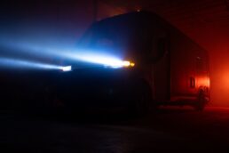 A vague exterior photo of the RVEX exterior with the headlights on.