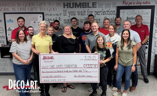 A photo of representatives from Dec-O-Art with a large check for the donation to the Care Camp Foundation.