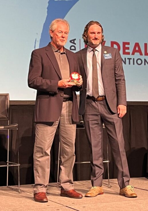 A photo of Larry Troutt Jr. receiving an RVDA Chairman's Service Award from his son, Larry Troutt III.