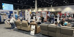 Attendees of the 2026 NTP-Stag Expo taking advantage of the display furniture on the show floor on the final day of the show.