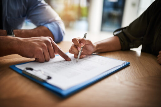 A stock photo of a man signing paperwork.