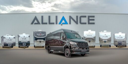 A photo of a fleet of Alliance RVs in front of the company's building.