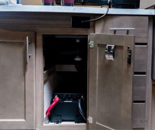 A Renogy semi‑solid‑state LiFePO₄ battery -- part of the Pro S1 series -- installed under an RV kitchen sink.