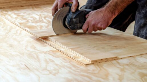 A stock image of a man cutting a sheet of lauan plywood with a circular saw.